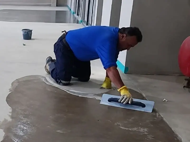 Aplicação de primer epóxi sobre piso industrial para promover aderência e uniformização da superfície em galpão de Sinop MT.